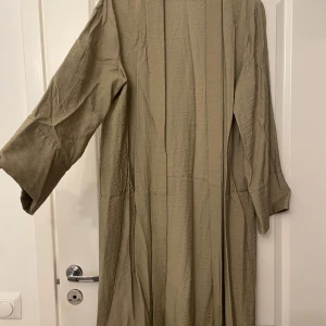 Abaya - Khaki grön abaya i linnen material, passar storlek M-L bra. ( köpt utomlands så storleken på lappen stämmer inte)