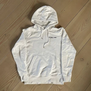 Helmut Lang Hoodie  - Tja, säljer denna vita Helmut Lang hoodie i storlek M. Nypris 4200kr. Skick: 8/10. Den är i bra skick förutom en liten skada på innersidan av fickan, men inget man varken märker eller ser. Den är också lite skrynklig men det går snabbt att stryka då det är vanligt bomull. Hör av er vid frågor eller funderingar!