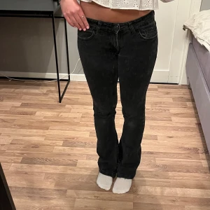 Lågmudjade bootcut jeans - Svarta bootcut jeans med leoparddetalj på insidan av benet. Storlek 36 men passar mer som 34. Innerbenslängd: 80cm💕Lite slitna längst ner men ingenting man tänker på!