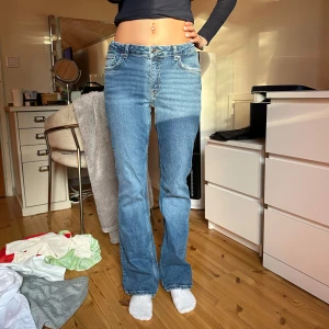 Blå bootcut jeans  - Säljer ett par klassiska blå jeans från Gina med bootcut passform och låg midja. Jeansen har fem fickor, ljus tvätt och tydliga sömmar. Perfekta för dig som gillar en avslappnad men ändå snygg stil💙