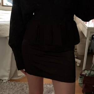 Svart kortkjol i satin - Jättesnygg svart kortkjol i satin, perfekt till fest!