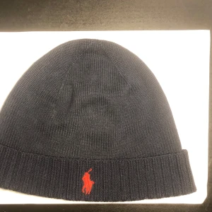 Polo Ralph Lauren mössa - En snygg Ralph lauren mössa som är knappast använd i den utsökta färgen ”marinblå” Mössan är självklart äkta. Tveka inte av att höra av dig vid minsta lilla fundering✌️ priset kan sänkas vid snabb affär!