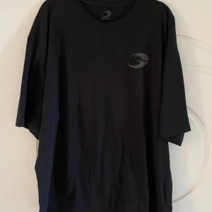 Svart oversized t-shirt från Gasp - Svart oversized t-shirt från Gasp med diskret logga på bröstet och stor text på ryggen. T-shirten har rund halsringning och är tillverkad i mjuk bomull. Perfekt för dig som gymmar! Hör av dig vid frågor och funderingar!