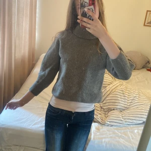 Grå polotröja i ull med trekvartsärm - Mysig grå polotröja med trekvartsärmar och avslappnad passform. Tröjan är stickad i ull och har en hög krage som ger en chill vibe. . Tror den har krympt i tvätten ngn gång jag köpte den second hand o så var den så här. Tycker inte det gör någonting bortsett från materialet känns lite tjockare och fylligare. Står S men mer en xs. Mer åt det bruna hållet än vad de ser ut som på bilden