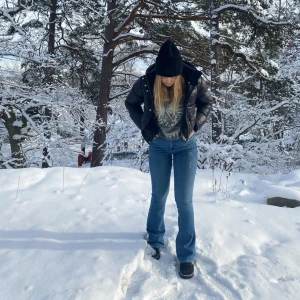 Blå bootcut jeans - Säljer ett par klassiska blå jenas med bootcut passform och hög midja. Jeansen har fem fickor, snygga kopparfärgade nitar och är tillverkade i slitstarkt denim. Perfekta för dig som gillar en tidlös och trendig look.