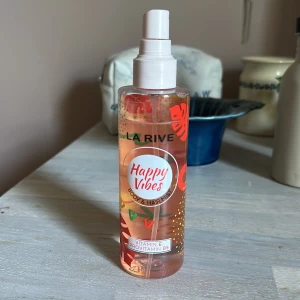 La Rive Happy Vibes Body & Hair Mist - Fräsch body & hair mist från La Rive i doften Happy Vibes, den är en somrig lukt lite tropiskt skulle man kunna säga. Deb Kommer i en genomskinlig plastflaska med färgglada detaljer och sprayfunktion. Innehåller vitamin E och provitamin B5. Flaskan rymmer 200 ml och har en rosa-orange tonad vätska.