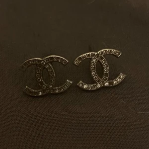 Eleganta örhängen  - Dessa örhängen är gjorda i silverfärgat material och har en elegant design som passar både till vardags och till festliga tillfällen. De är endast använda ett fåtal gånger vilket gör att de är i mycket gott skick. Örhängena är lätta att bära och sitter bekvämt hela dagen. De fungerar bra som en snygg detalj till många olika outfits och kan enkelt kombineras med både casual och mer uppklädda stilar. Perfekta för dig som vill ha ett prisvärt smycke med en klassisk och tidlös känsla.