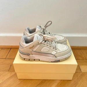 Axel Arigato Area Lo sneakers beige/vit - Snygga Area Lo sneakers från Axel Arigato i beige och vitt skinn med grå detaljer.  Super fräscha, bara använts ett fåtal gånger eftersom de tyvärr är för små för mig. Nypris 3,350