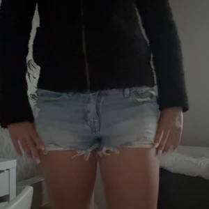 Ljusblå jeansshorts med fransar - Snygga ljusblå jeansshorts från Perfect Pants med råa fransade kanter och slitna detaljer framtill. Klassisk femficksmodell med bälteshällor och knappgylf. Perfekta för varma dagar och en avslappnad look.