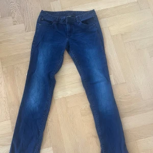 Mörkblå jeans från Armani Exchange - Snygga mörkblå jeans från Armani Exchange med klassisk femficksdesign och raka ben. Byxorna har en metallogo bak och läderpatch i midjan. Modellen heter J5 Straight och är tillverkad i mjukt bomullsjeansmaterial. Perfekta för en clean och stilren look.