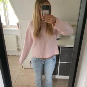 Ljusrosa stickad tröja från Gina tricot - Supermysig ljusrosa stickad tröja från Gina tricot Tröjan har en relaxed fit med rund halsringning och långa ärmar. Perfekt att slänga på sig när det är kyligt ute. Mjuk och fluffig känsla, passar till jeans eller kjol.