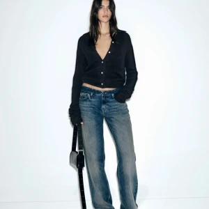 Blåa low waisted jeans - Snygga blå jeans med straight-stil och låg midja. Perfekta för en avslappnad look. Klassisk femficksdesign och knappgylf.