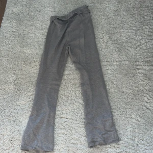 Beige  hoodie med matchande byxor -   Mysig beige stickad hoodie med dragkedja och långa ärmar. Den har en ribbad nederkant och muddar. Tillhörande byxor i samma beige stickade material med ribbade detaljer vid midja och benslut. Low waist!