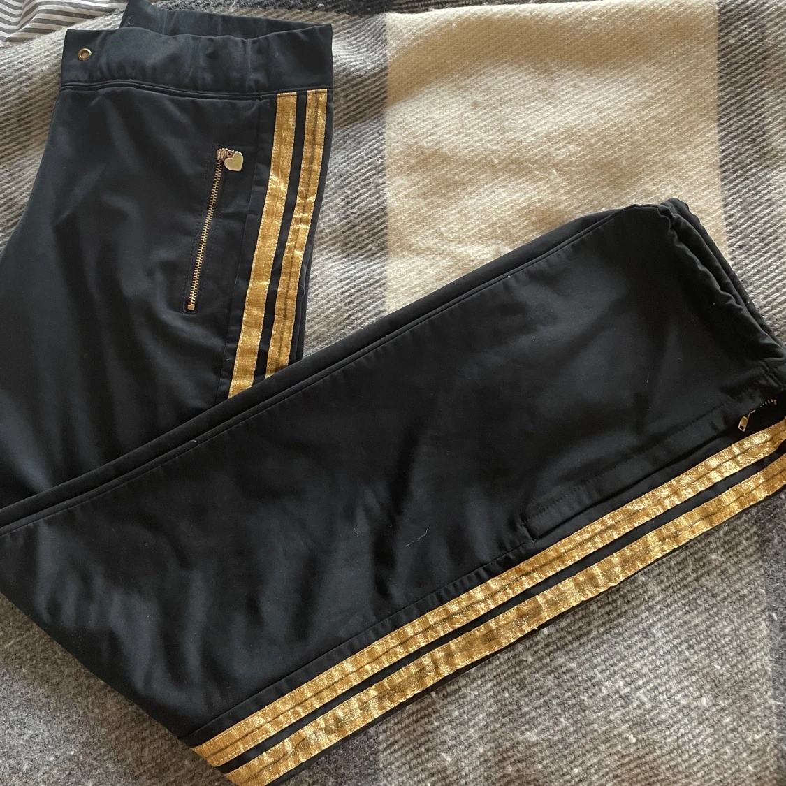 Svarta byxor med guldiga detaljer