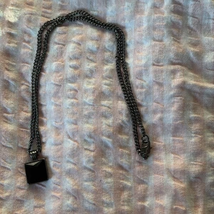 Svarta halsband med hängsmycken - Två stilrena svarta halsband med olika kedjedesign. Det ena har ett fyrkantigt hängsmycke och det andra ett runt hängsmycke. Perfekta för att ge en edgy touch till din outfit.