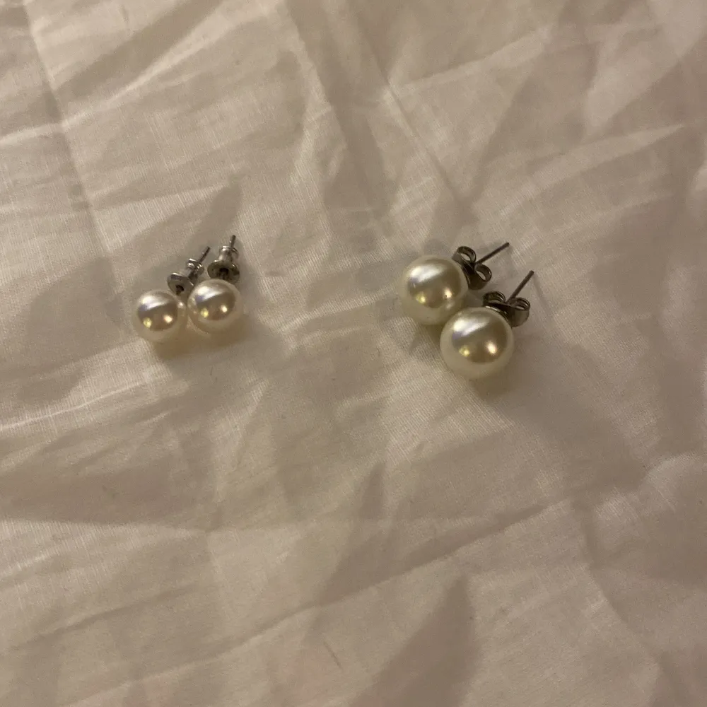 Säljer två par eleganta pärlörhängen med silverfäste. Perfekta för att ge en klassisk touch till din stil. Passar både till vardag och speciella tillfällen.. Asusteet.