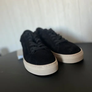 Svarta sneakers från Vagabond - Snygga svarta sneakers från Vagabond med en stilren design. Skorna har en överdel i mocka och en ljus sula som ger en fin kontrast. Perfekta för en avslappnad stil. Mycket fint skick, skulle nog säga använd 1-2 gånger. Storleken står 41 men skulle nog passa 42. Pris kan diskuteras!