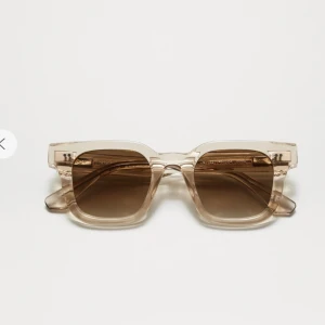 Beige solglasögon med transparent bågen/ chimi 04 ecru  - Snygga solglasögon med en fyrkantig form och transparent beige båge. De har mörka linser som ger ett stilrent intryck. Perfekta för en solig dag! Snabbt köp 800