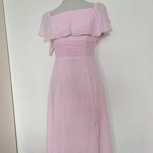 Rosa balklänning med slits  - Dragkedja i bak. Den är aldrig använd, har tags. Uppskattar att den passar XS, möjligtvis en XXS också.