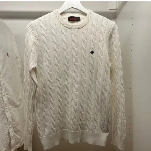 Morris stickad tröja  - Säljer en stilren vit stickad tröja från Morris med ett diskret broderat emblem på bröstet. Tröjan är i storleken är XS och skicket är mycket bra. Meddela gärna om du har frågor.