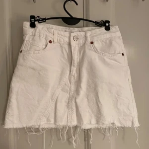Vit jeanskjol - Snygg vit jeanskjol från Zara! Kjolen har en knapp och dragkedja framtill. Perfekta till sommaren!!