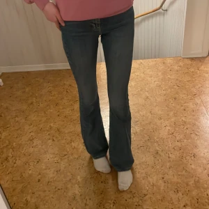 Blå bootcut jeans - Snygga blå bootcut jeans med en klassisk look. De har en bekväm passform och är perfekta för en avslappnad stil. Jeansen har en traditionell femficksdesign och en knappgylf.