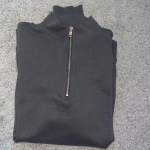 Mörkgrå tröja med dragkedja från ASOS DESIGN - Säljer en mörkgrå tröja från ASOS DESIGN. Säljer då den knappt kommit till användning. 