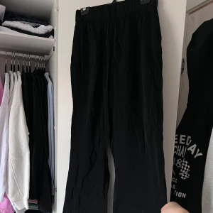 Svarta byxor med resårmidja - Snygga svarta byxor med resårmidja för en bekväm passform. Byxorna har en loose stil och är perfekta för en avslappnad look. Tillverkade i ett lätt material som ger en skön känsla. Byxorna har blivit lite noppriga men jag kan använda avnoppringsmaskin på de innan jag skickar, om så önskas ☺️ Önskar du veta exakta mått? Tveka inte att höra av dig!