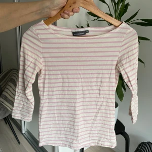Randig topp från Rosemunde - Säljer en söt randig topp från Rosemunde i storlek 34. Den har ljusrosa och vita ränder och trekvartsärmar. Perfekt för en avslappnad stil. 🌸