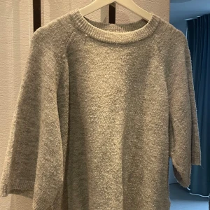 Grå tröja från 157 - Stickad grå tröja från 157 i en mjuk blandning av akryl, polyester och elastan. En del noppror.