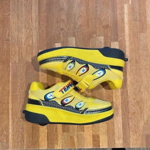 Gula sneakers med hjul från Tengren - Coola gula sneakers med hjul från Tengren. Skorna har en färgglad design med snörning och kardborreband. Perfekta för dig som vill rulla fram med stil! Perfekta skor för att ha kul i varje fotsteg. Hjulen går att justera till normala skor och justera upp hjulen för att börja rulla!