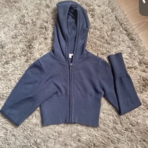 Blå croppad hoodie från Gina Tricot - Säljer en snygg blå croppad hoodie från Gina Tricot. Den har en dragkedja framtill och långa ärmar med ribbade muddar. Perfekt för en avslappnad stil. Hör av dig vid intresse! 💙