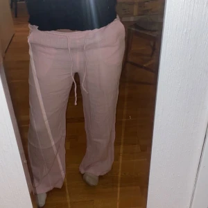 Rosa mjukisbyxor med snörning - Säljer ett par bekväma rosa linnebyxor med snörning i midjan. De är tillverkade i ett mjukt material som gör dem sköna att bära. kostar runt 400kr på gina 