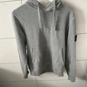 Stone island hoodie - Sugen på en klassisk Stone Island sweatshirt i tidlös svart? Den här är i 100 % äkta vara och redo att bli din! * Autenticitet: För din trygghet finns en QR-Kod som bevisar äktheten (se bilder). Jag har dolt den i annonsen for att skydda den mot ogiltigförklaring. Skicka ett meddelande sà far du koden direkt! * Märke: Stone Island * Färg: Svart * Storlek: S * Skick: Perfekt skick - 10/10! Material: Högkvalitativt tyg för maximal komfort och hällbarhet. Den ikoniska Stone Island-kompassen på ärme