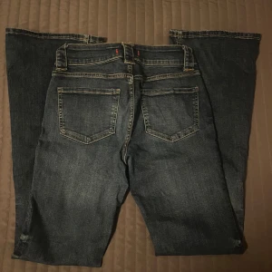 Blå bootcut jeans från Zara, stl 36 - Snygga blå jeans från Zara med klassisk bootcut-modell och femficksdesign. Jeansen har kontrastsömmar och en mörk tvätt som ger en stilren vibe. 
