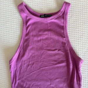 Ribbad rosa linnetopp från Zara - Säljer en ribbad rosa linnetopp från Zara i storlek M. Toppen har en ärmlös design med breda axelband och rund halsringning. 