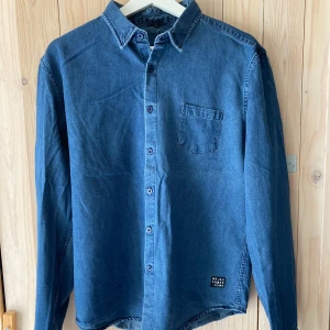 Örjan Andersson jeansskjorta - Använd kanske en gång, perfekt skick. Storlek Medium. Upphämtning i Stockholm fungerar.