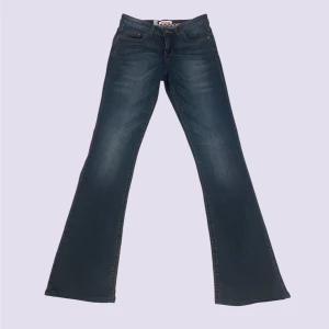 Blå bootcut jeans John Baner - Snygga blå bootcut jeans från John Baner med klassisk femficksdesign och dekorativa sömmar på bakfickorna. Mid waist. Storlek 36. Midja: 37cm rakt över, innerbenslängd: 80cm