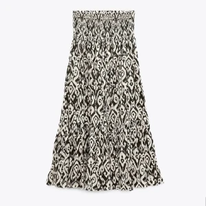 Zara kjol - Snygg långkjol i svart och vitt med ett unikt grafiskt mönster. Kjolen har smockad midja och volangdetalj nertill som ger en flowy känsla. Perfekt för dig som vill sticka ut med en cool och bekväm stil.
