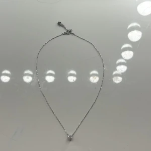 Swarovski halsband med kristall - Ett stilrent halsband från Swarovski i silver med en tunn kedja och en gnistrande rund klar kristall som hänge. Kedjan har en liten svanberlock vid låset, vilket är Swarovskis ikoniska logga. Perfekt för dig som gillar smycken med lite extra bling.🤍