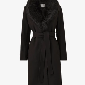 Svart kappa med fuskpäls från ONLY - Stilren svart kappa från ONLY med lång passform, bälte i midjan och bred krage i fuskpäls. Jackan har långa ärmar och en klassisk siluett som ger en snygg look. Perfekt för dig som vill ha en elegant vibe under kalla dagar. Man kan även ta bort pälsen! Bara dessa två första bilderna är från Hollies, inte Only, men tänkte ha med bilderna om ni ville se hur det ser ut i helhet eftersom dem är ganska lika. Har bara använt den några gånger. Dem frångar allas uppmärksamhet 🌸 priset kan diskuteras ♡