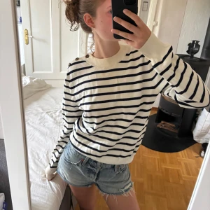 Randig tröja - Randig stickad tröja med knapar på ena axeln, tröjan är använd men i fint skick.