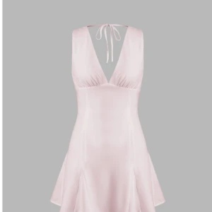 Ljusrosa satin klänning - Supersöt ljusrosa kortklänning i satin med v-ringning och knyt i nacken. Klänningen har en lätt utsvängd kjol och är ärmlös, perfekt för sommarkvällar eller när du vill känna dig extra fin.