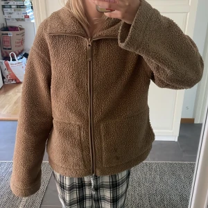 Teddyjacka - Mysig beige teddyjacka med dragkedja framtill och stora fickor. Säljer för att den är för stor för mig och den har två fläckar men jag kan nog tvätta den så går de säkert bort skriv för frågor eller bilder!!💕Den är i väldigt bra skick!Jackan har en avslappnad passform och är tillverkad i fluffigt fleece-material som håller dig varm. Perfekt för kyliga dagar och enkel att styla till olika outfits.