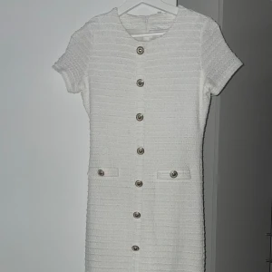 Vit kortklänning med knappar - Superfin vit långklänning med strukturerat tyg och snygga silvriga knappar framtill. Inte genomskinlig! 🤍