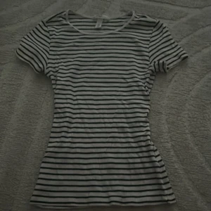 Randig vit och svart topp - Säljer en klassisk vit topp med svarta horisontella ränder. Modellen är figurnära med rund halsringning och korta ärmar. Perfekt för en chill och stilren look, enkel att matcha med jeans eller kjol, skriv vid funderingar☺️☺️