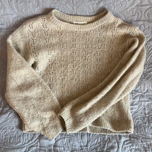 Beige stickad tröja från H&M - Mysig beige stickad tröja från H&M med fint hålmönster. Tröjan har rund halsringning och långa ärmar. Skulle säga att den är ganska kort! Skicka för frågor💓💓💓💓 storleken är 146/152 men passar på mig som har xs/s men den blir kortare då! 