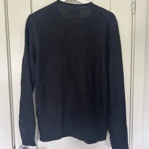 Svart långärmad tröja från Replay - En stilren svart långärmad tröja från Replay. Tröjan har rund halsringning och är tillverkad i ett mjukt material som passar perfekt till vardags. Enkel och klassisk design som är lätt att matcha med andra plagg.