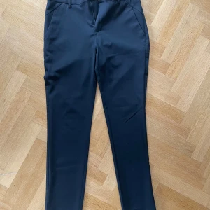 Svarta kostymbyxor från Plain - Snygga svarta kostymbyxor från Plain med klassisk rak passform. Byxorna har fickor fram och bak, samt stängs med dragkedja och knapp. Perfekta för en stilren look och passar till många tillfällen. Kan gå ner i pris vid en snabb affär 