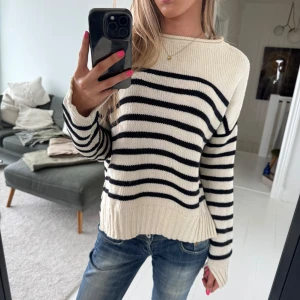 Randig stickad tröja från Zara Knit - Säljer en krämvit stickad tröja med svarta horisontella ränder från H&M. Tröjan har en avslappnad passform med slits på sidorna, rund halsringning och långa ärmar med slits längst ned!💓 Perfekt för lager-på-lager och enkel att styla till jeans.🫶hör av er vid fler frågor!